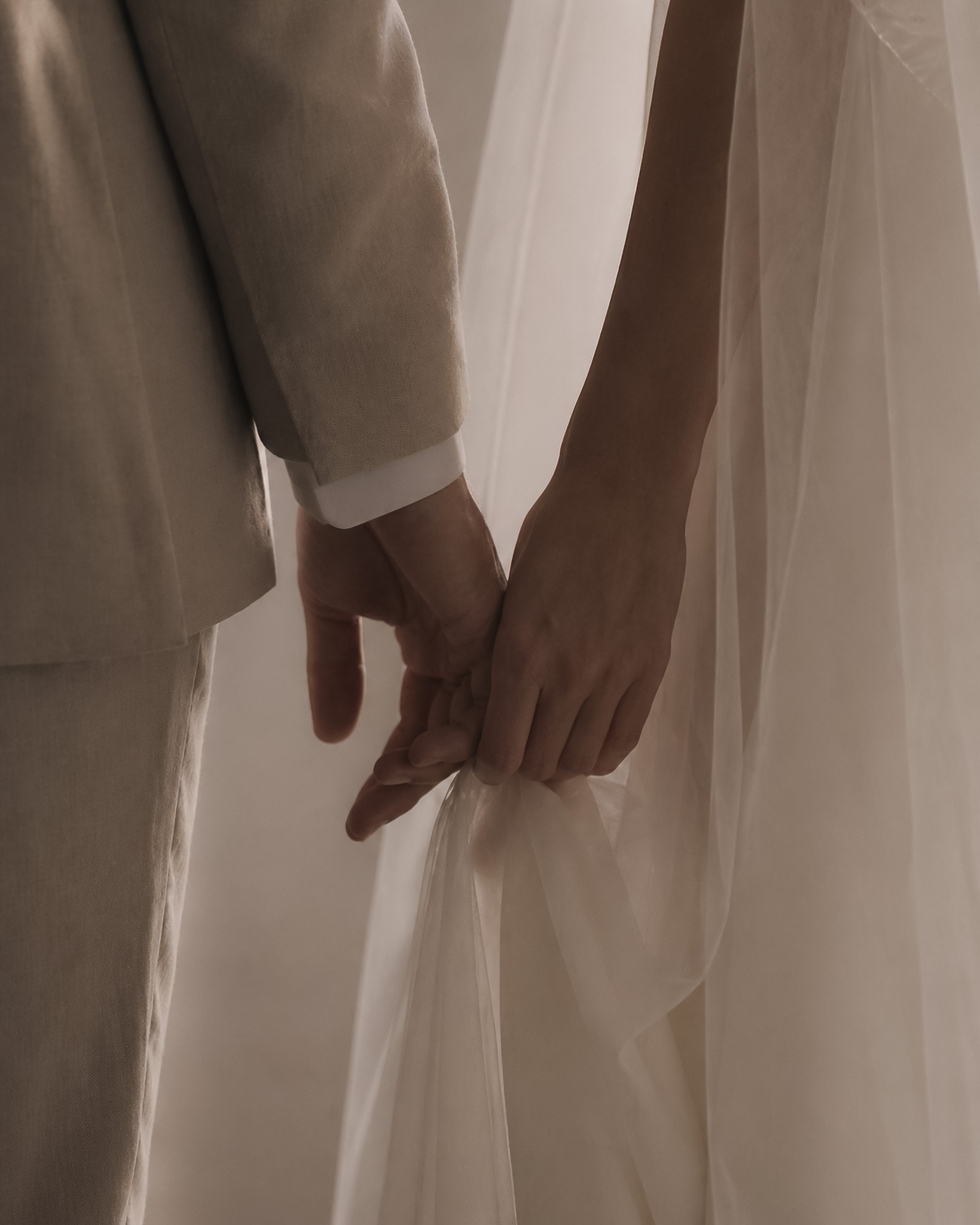Close detail of hands, veil and human gesture during a wedding moment