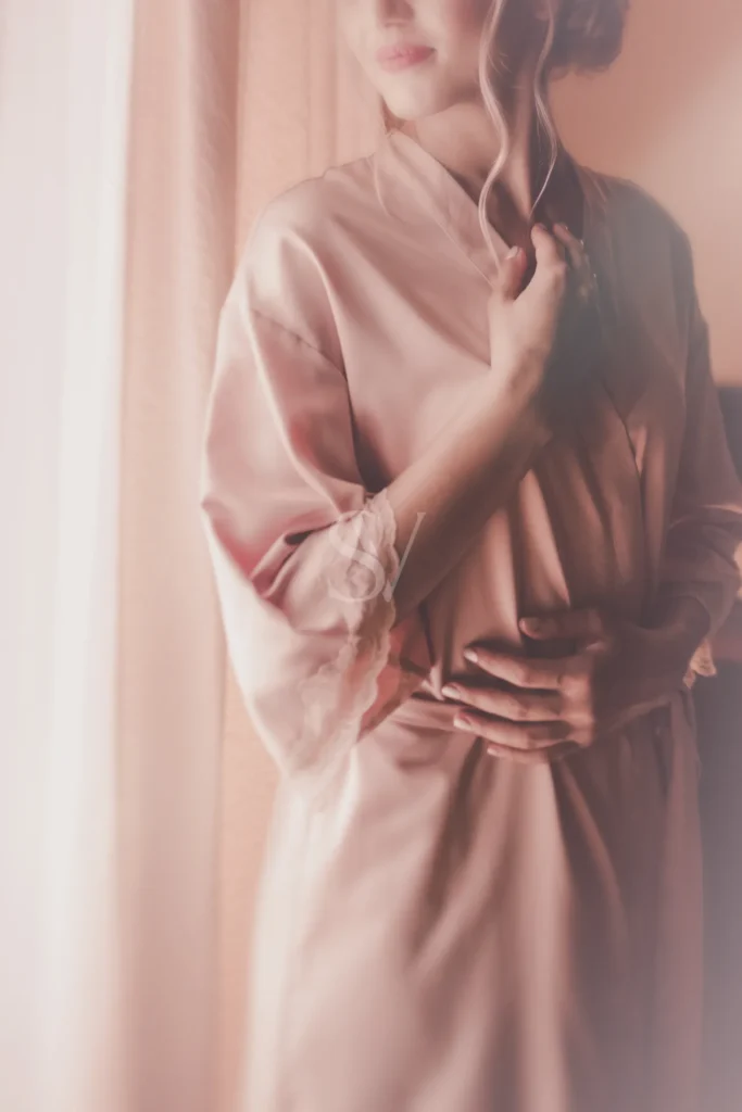 Bride in a pink robe during a quiet preparation moment