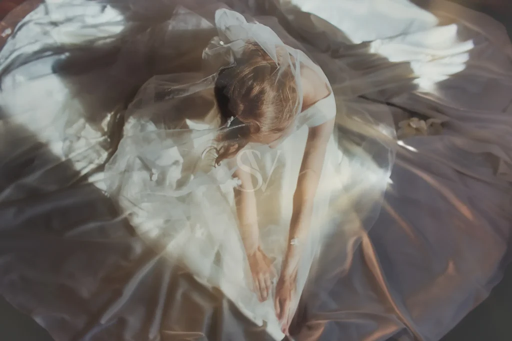 Bride surrounded by flowing wedding dress fabric