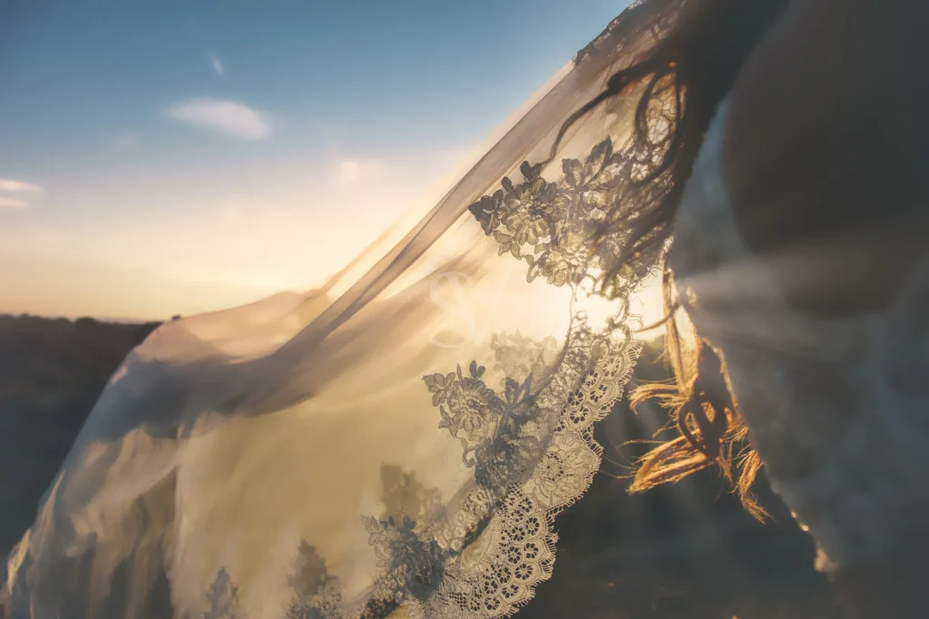 Bride under a lace veil in warm evening light