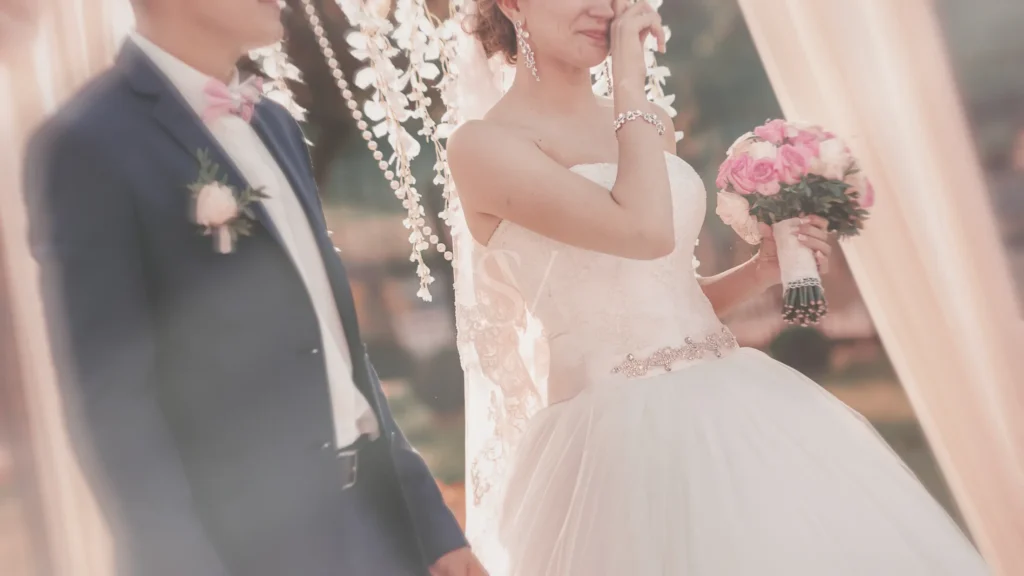 Emotional moment of bride holding a bouquet during an outdoor wedding ceremony