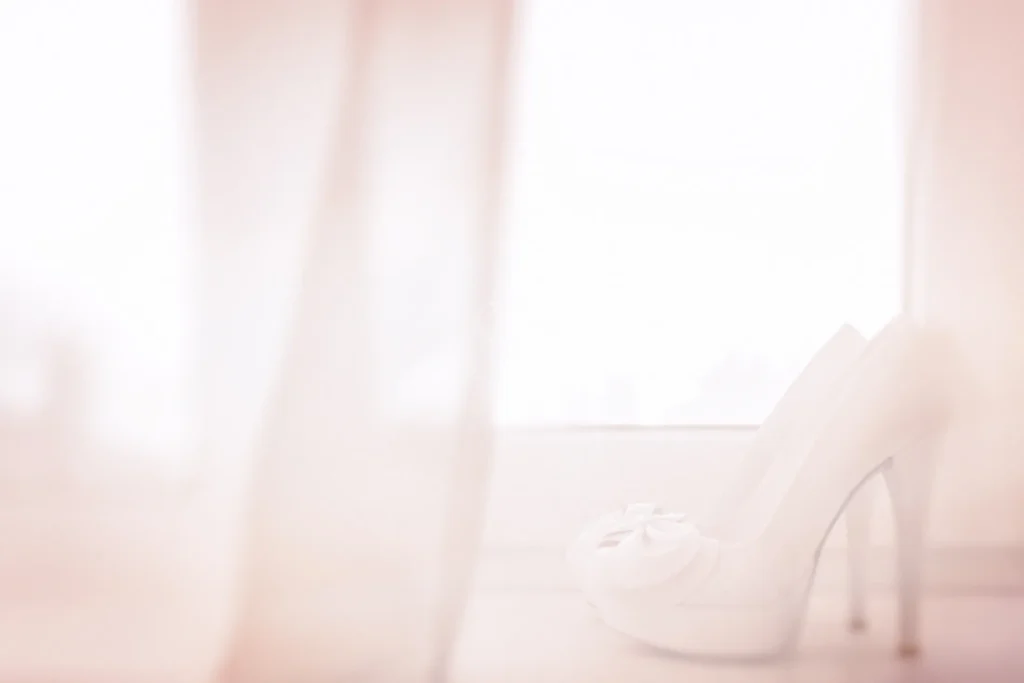 White bridal heels near soft window light