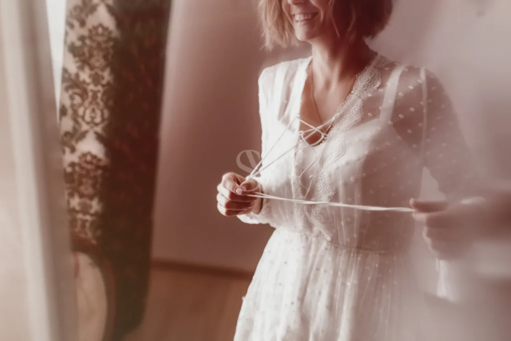 Bride tying a robe during a quiet preparation moment