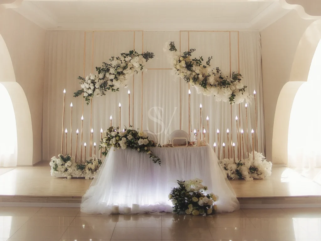 Wedding reception table with white floral arrangements and candle lights