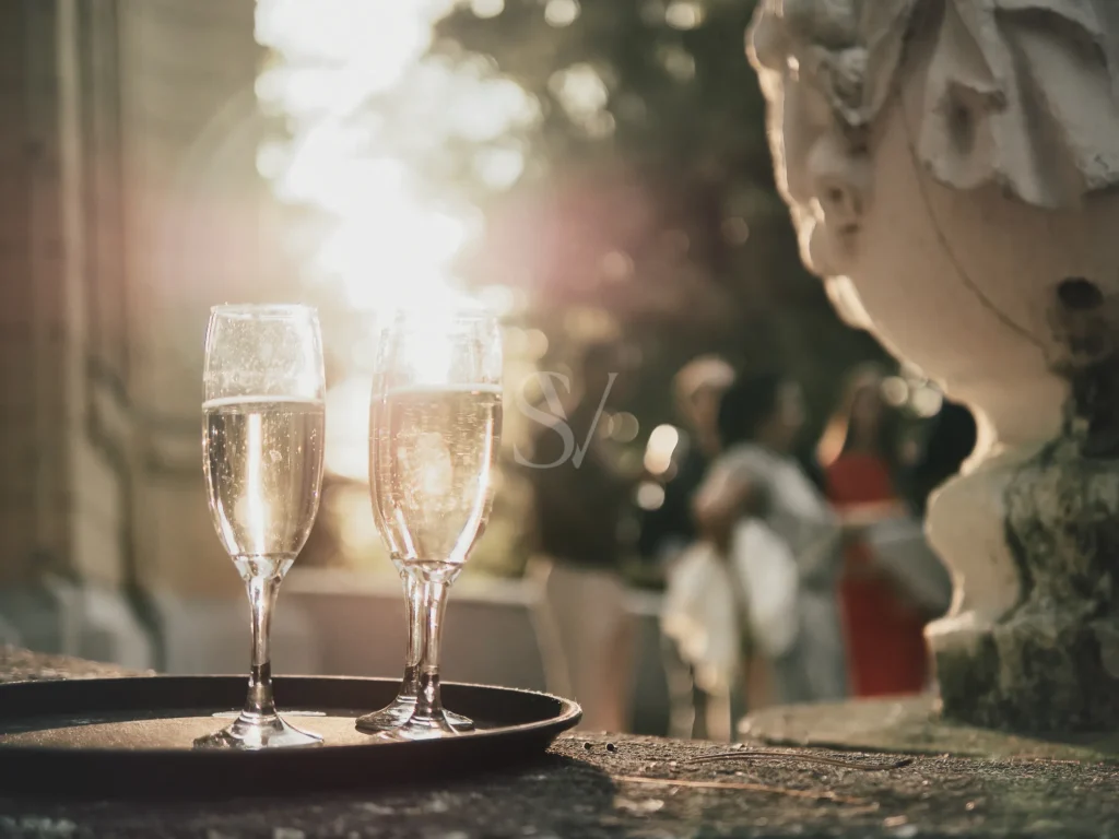 Two champagne glasses on a tray in warm outdoor wedding light