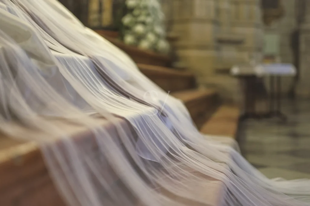 Sheer wedding veil fabric draped across a quiet church interior