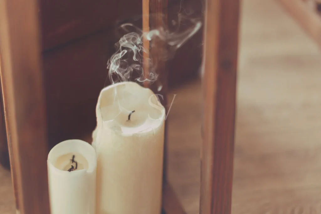 Extinguished candles with smoke in warm window light