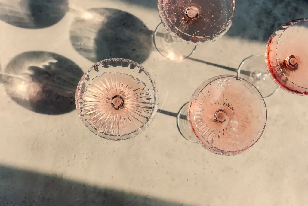 Overhead view of glasses with pink drinks and soft shadows